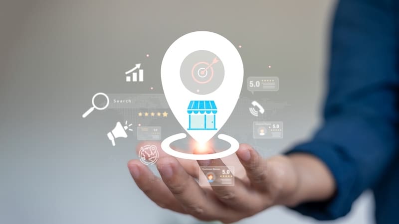 A person's hand faces up and above it are various local SEO icons, such as a business building, a location marker, a magnifying glass and more.