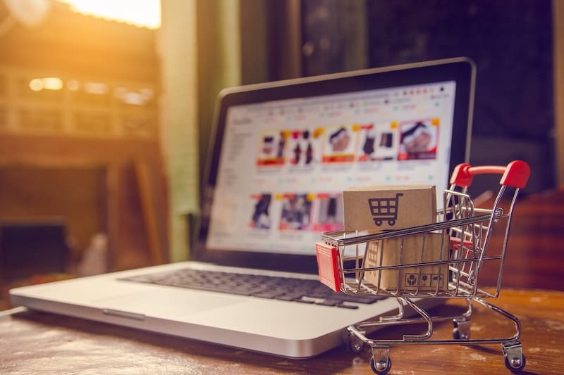 Shopping online concept - Parcel or Paper cartons with a shopping cart logo in a trolley on a laptop keyboard. Shopping service on The online web. offers home delivery.