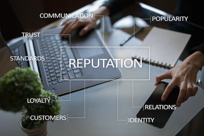 A person using a laptop with the word reputation written on it, seeking guidance from reputation management consultants.