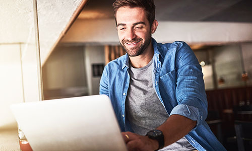 man on laptop smiling