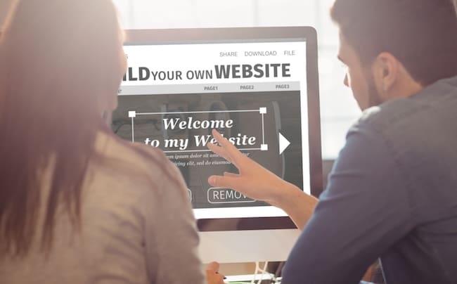 Two people looking at a computer screen that says build your own website to bury negative search results.