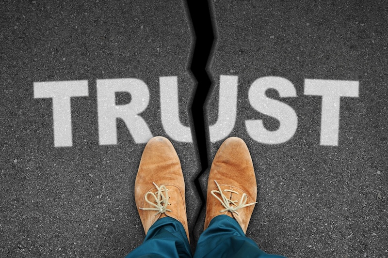 A person standing on a road with the word trust written on it, working to restore their online reputation.