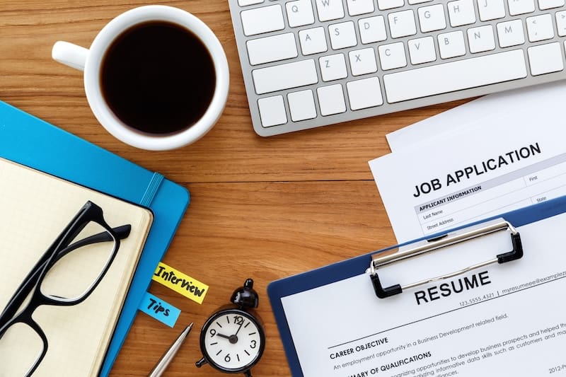 An online reputation restoration job application on a desk with a pen and paper.