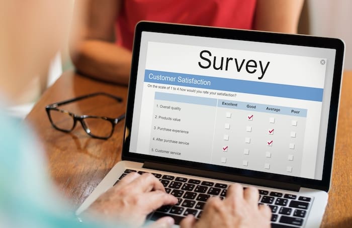 A person is using a laptop to complete a reputation builder survey.