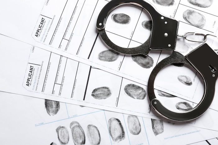 A fingerprint identification card with handcuffs and mugshot removal.