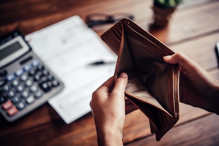 A person holding an empty wallet and wondering how to get their mugshot removed.