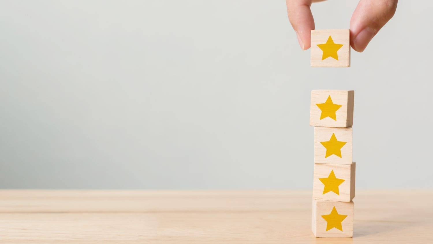 A person stacking wooden blocks with stars on them.