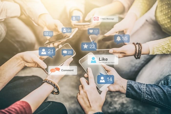 A group of people holding phones, showcasing the negative impacts of social media on business.