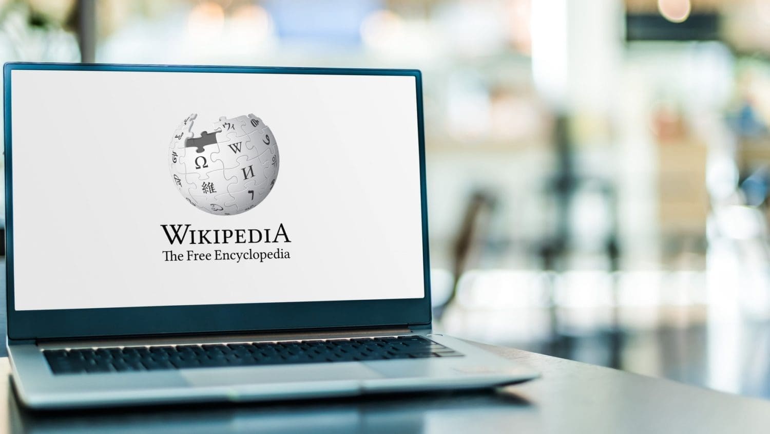 a laptop with the wikipedia logo on it is sitting on a table.