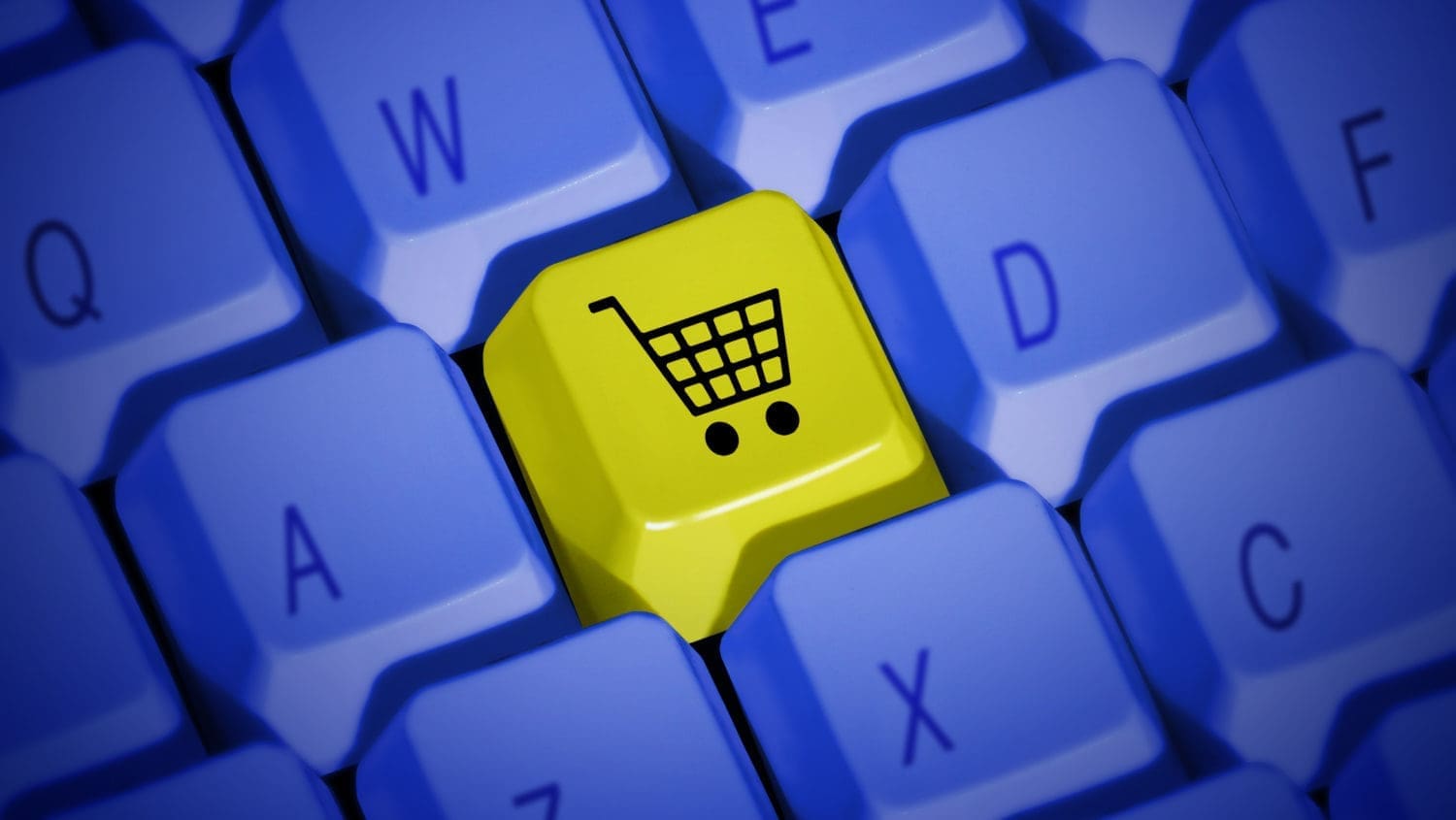 A yellow shopping cart on a blue keyboard.