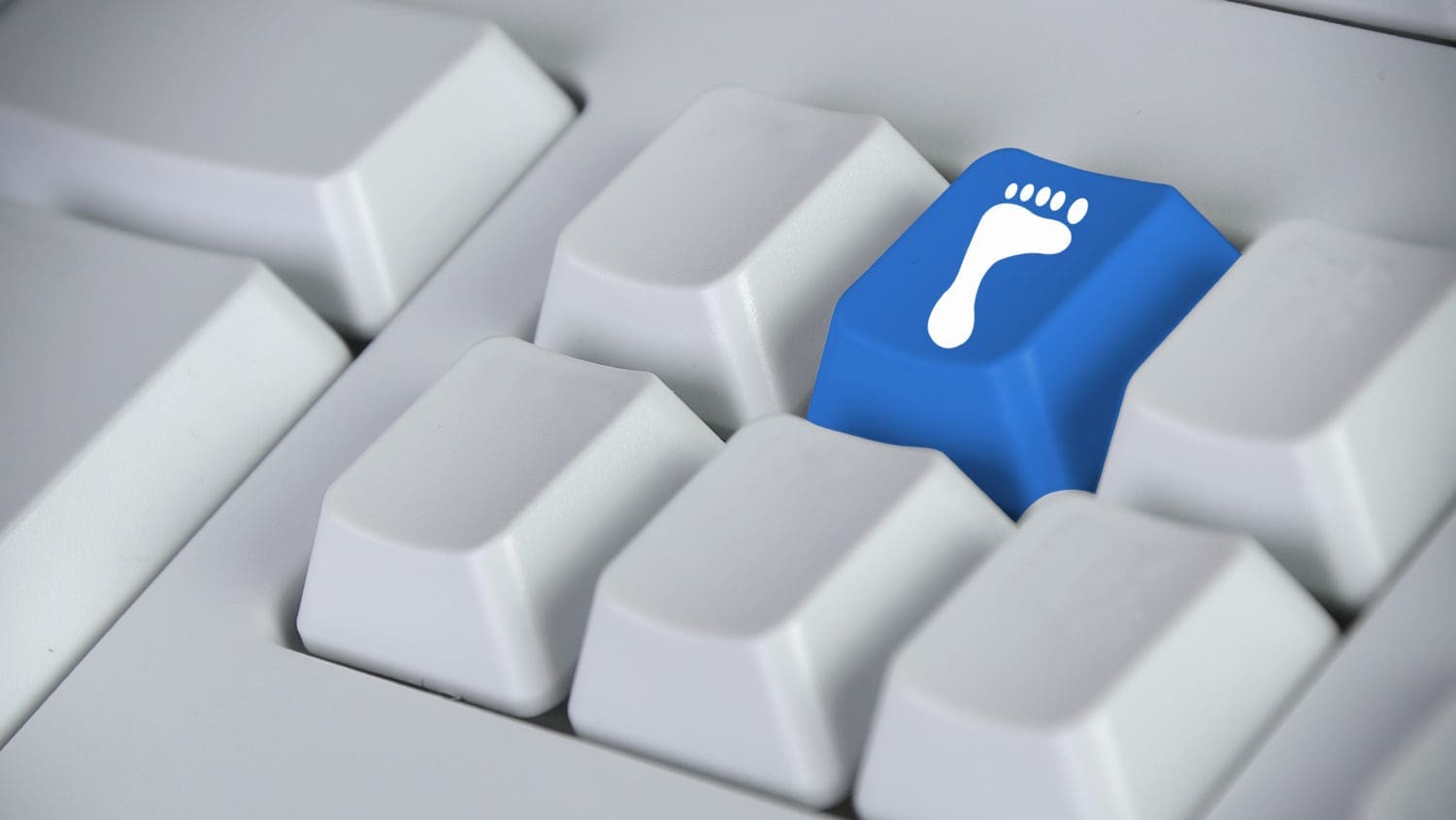 A blue button with a foot on it on a computer keyboard.