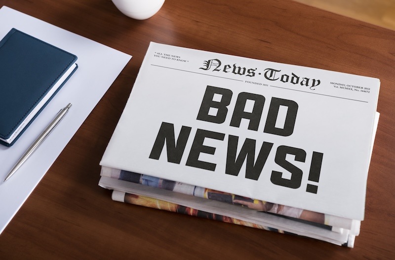 A newspaper with the headline "bad news" on it sitting on a desk, providing information on how to remove articles from the internet.