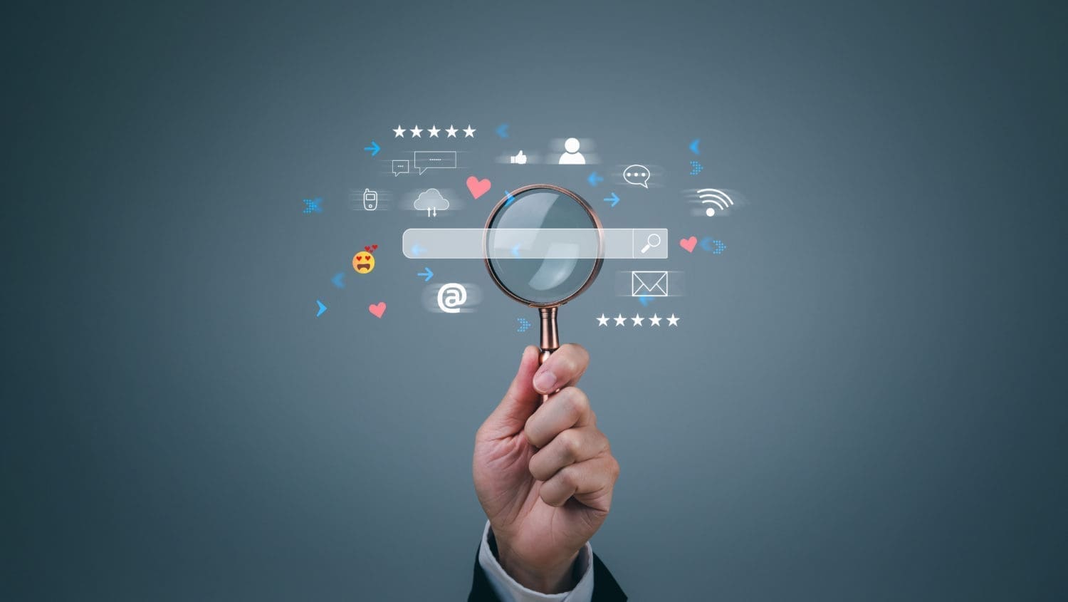 A hand holding a magnifying glass with social icons on it.
