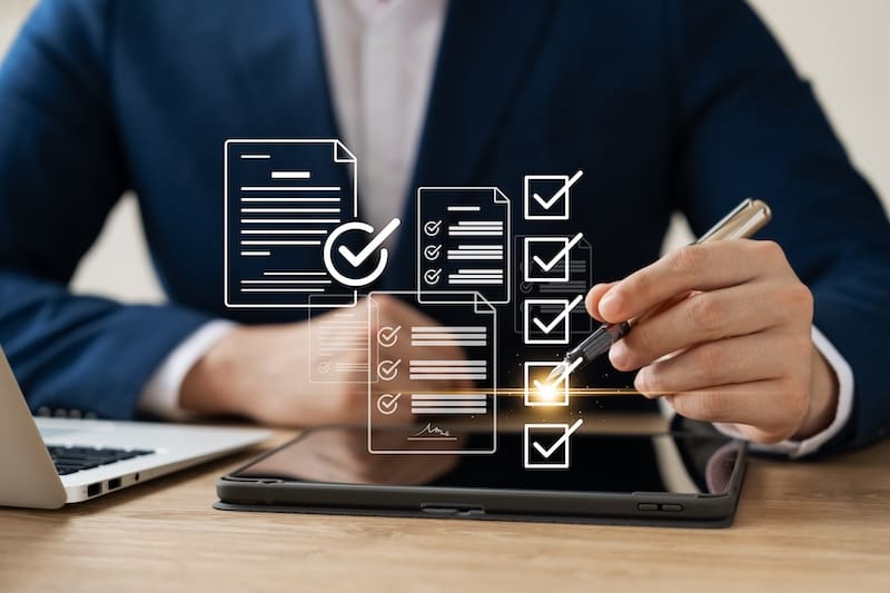 A man in a suit diligently drawing a checklist on a tablet to restore his online reputation.