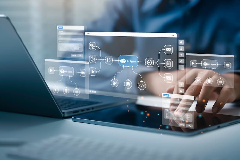 A person works at a laptop and an automation workflow shows on the screen.