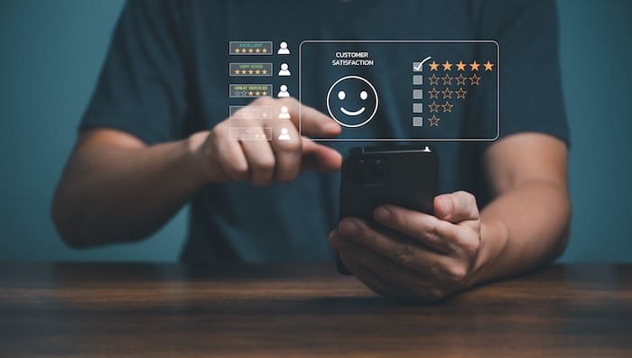 A man using a smartphone with a smiley face on it.