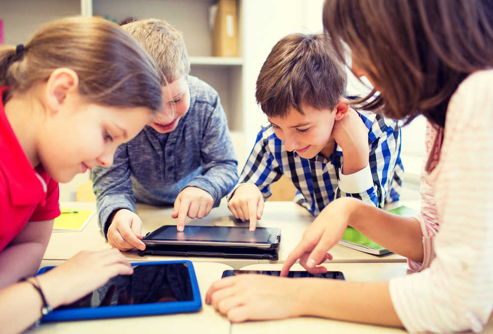 Children playing on computer tablets not knowing how to protect their privacy online