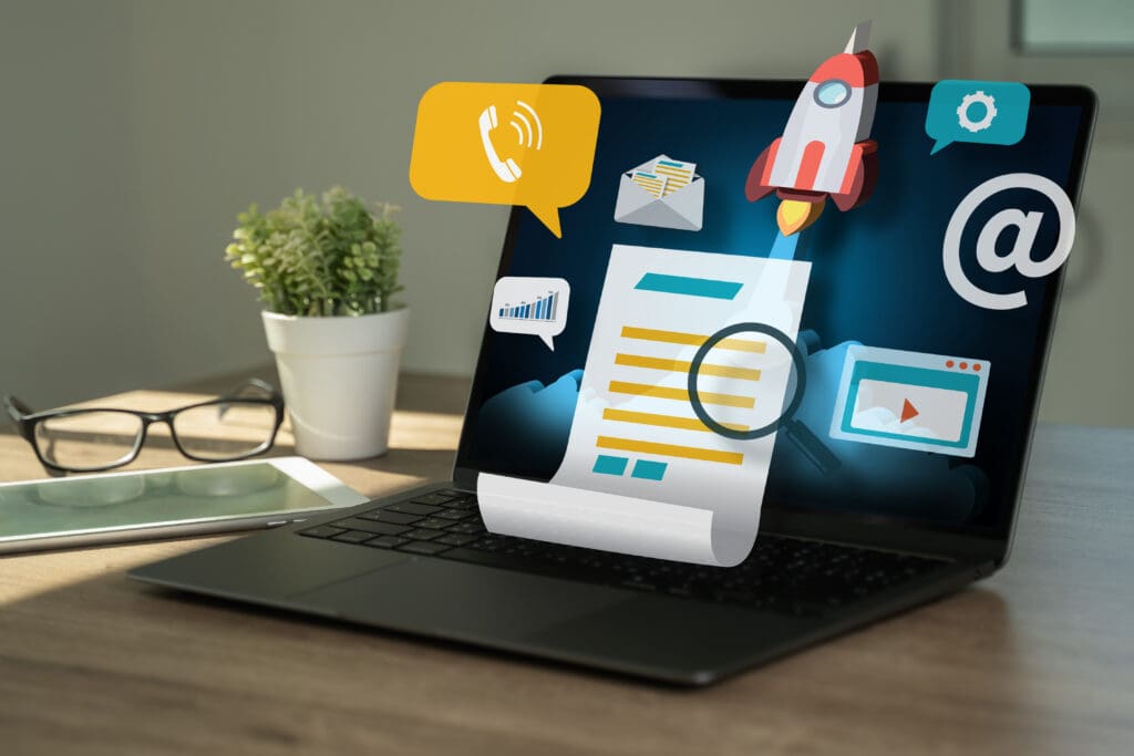 A laptop sits on a desk and graphics overlaid show a blog post, phone, and rocket launching.