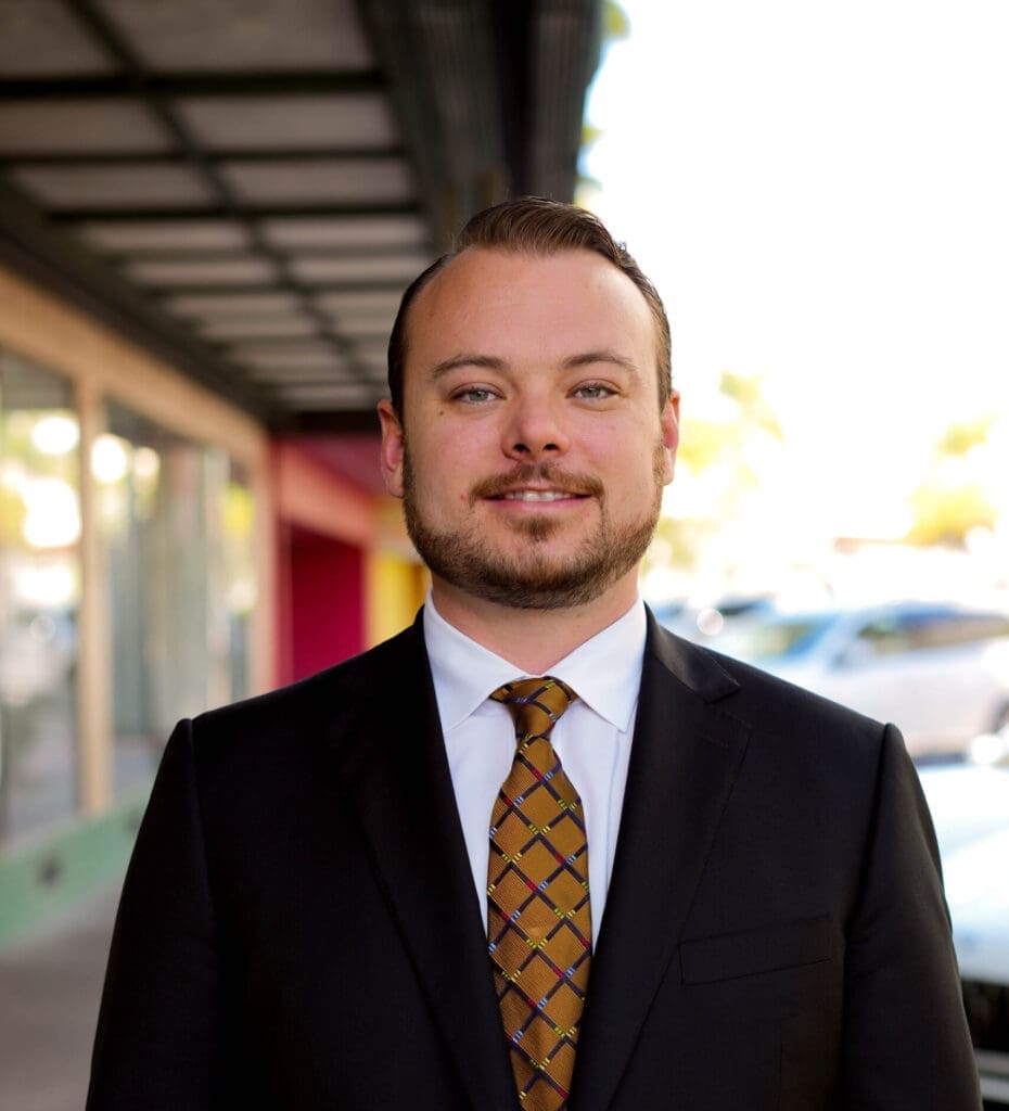 a man in a suit and tie standing in front of a building.