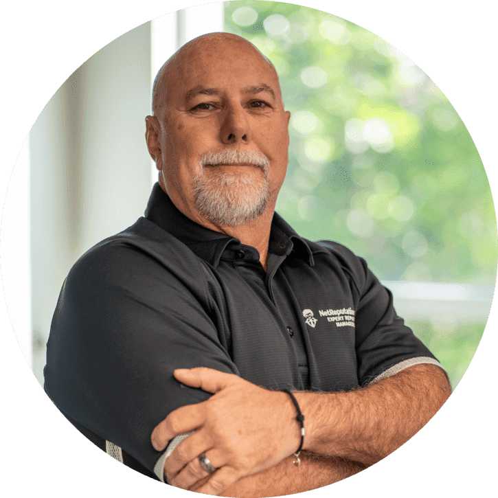 A man in a blue shirt with his arms crossed.