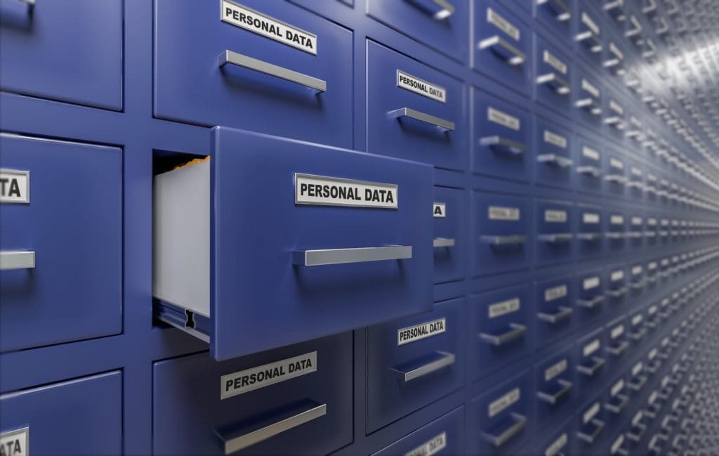 A close-up view of open blue filing cabinets labeled "personal data" in a vast, neatly arranged archival room, illustrating data storage and management.