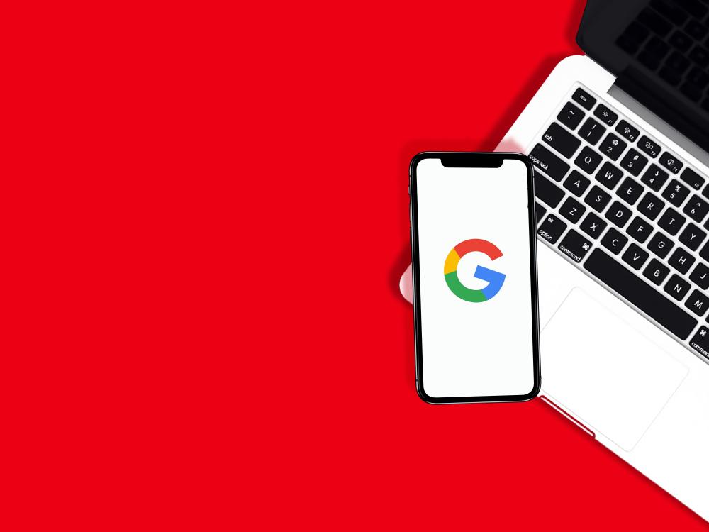 A laptop with a google logo on it on a red background.