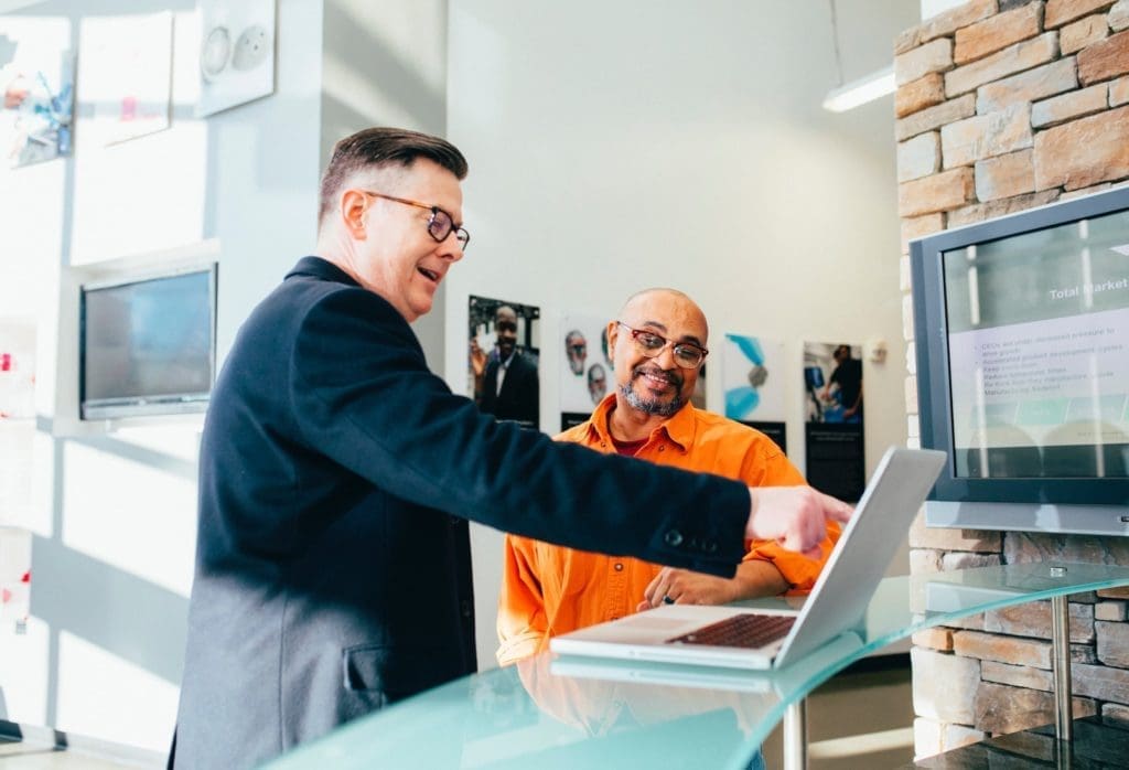 net reputation - two men pointing at laptop