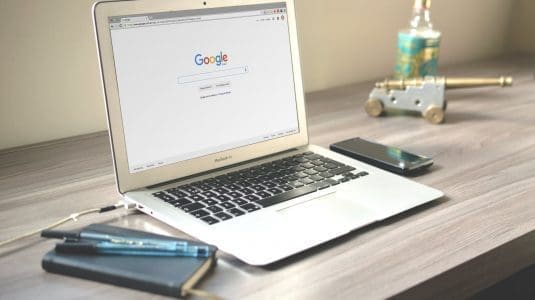 laptop on Google on clean wooden desk