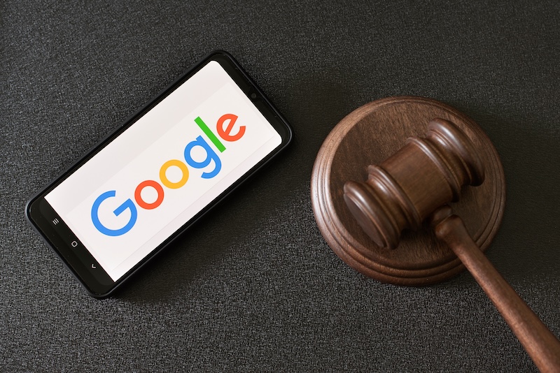 A phone with the google logo and a gavel on it.