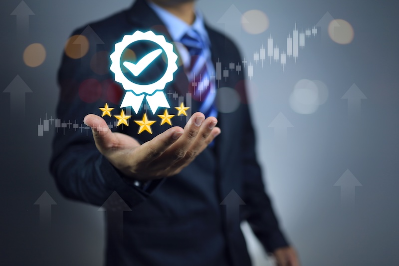 A businessman holding a star with five stars in his hand, showcasing his best reputation management results.
