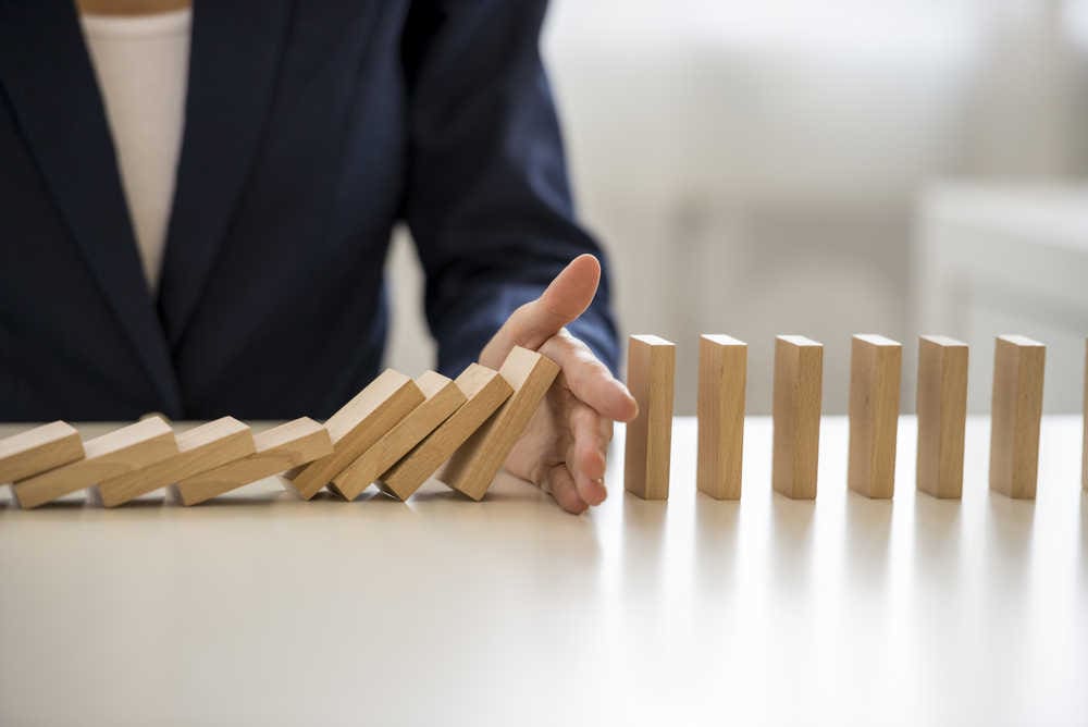 Dominos that are stopped from falling down to demonstrate that responding to negative reviews before you remove negative reviews can limit the fallout of bad feedback.