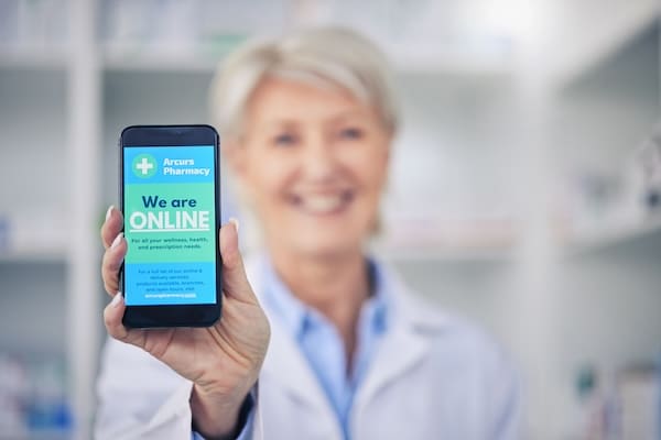 Woman holding a phone that shows her brand online.