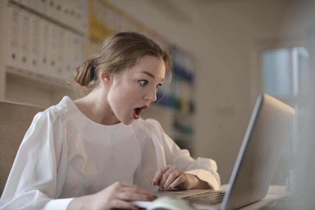 woman shocked reading on her computer